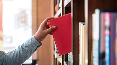 hand putting book back on shelf