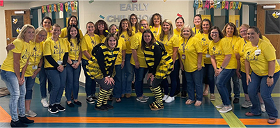 Happy group of ECLC teachers and staff in yellow t-shirts