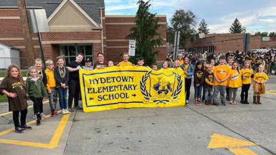 Hydetown Elementary students holding yellow Hydetown Elementary School banner