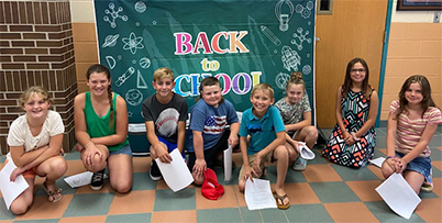 students in front of a back to school sign