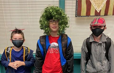 three students with wacky hair or hats