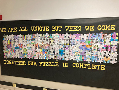 A Puzzle on a wall with the words we are all unique but when we come together our puzzle is complete